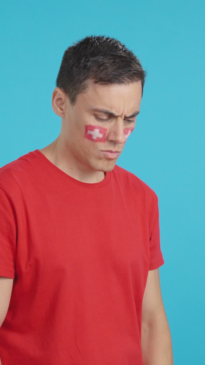 Man with swiss flag painted looking away with serious expression