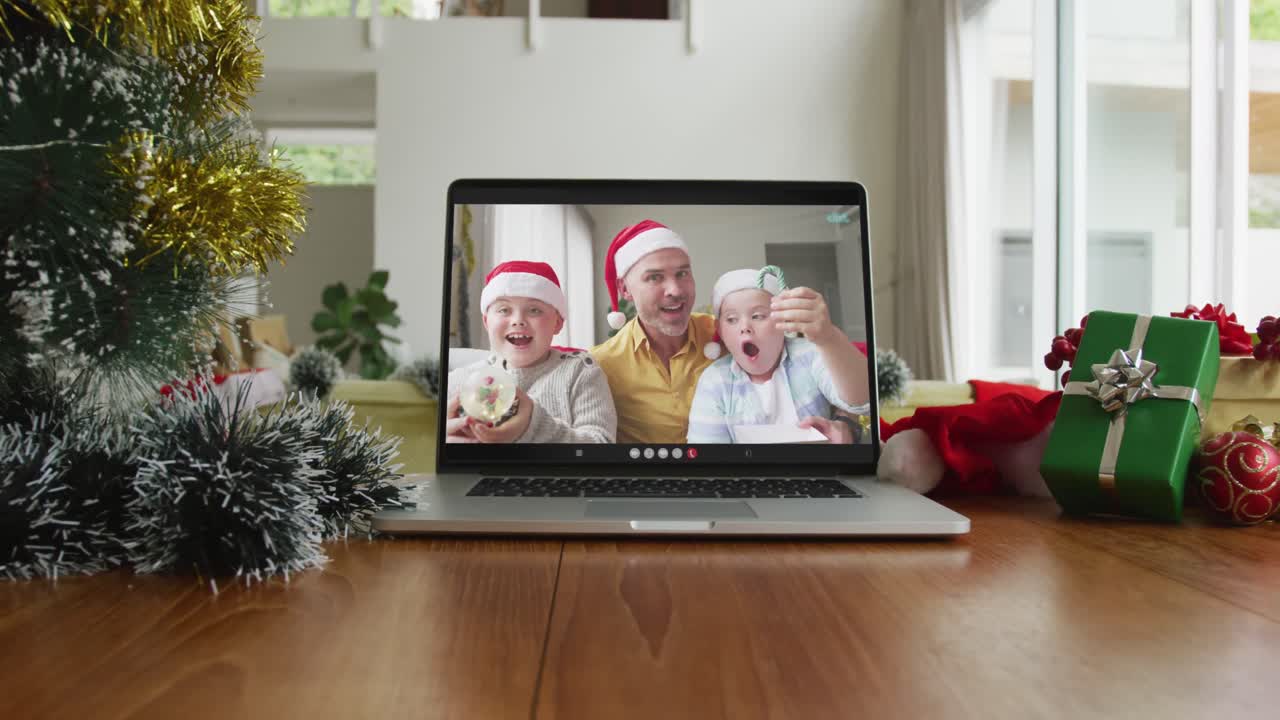 familia caucásica sonriente con sombreros de santa en la videollamada de navidad en la computadora portátil