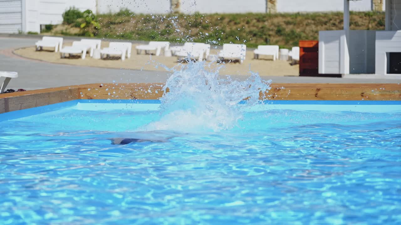 Mand hopper i swimmingpool. Ung atletisk mand hopper i poolen.