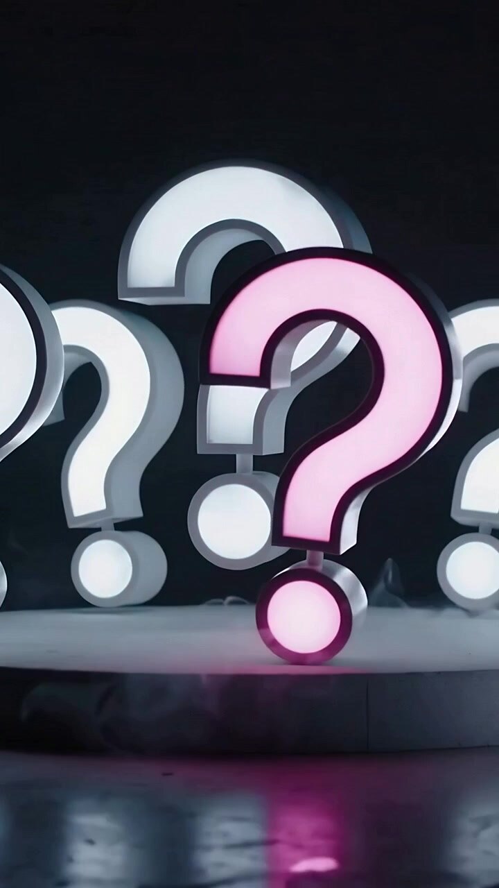 Video verticale: Telecamera che si sposta rivelando un punto interrogativo illuminato di rosa che avanza su una pedana per mettere a fuoco.