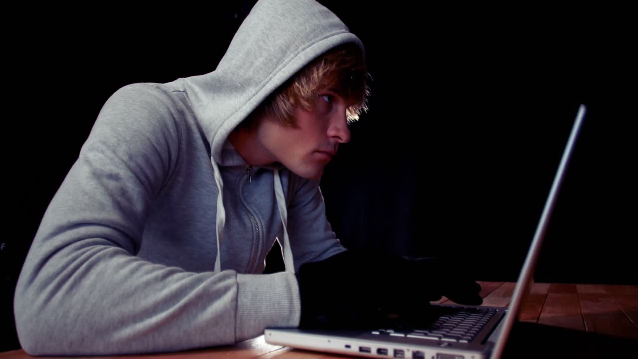 Hacker che usa il laptop per rubare l'identità