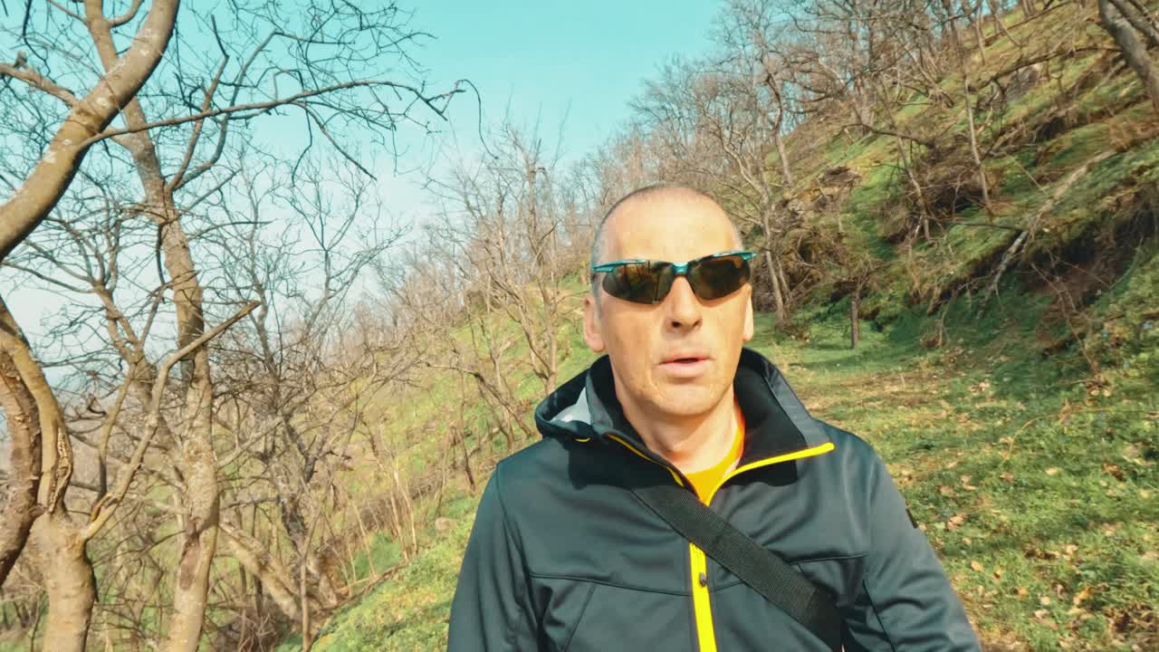 Stylish senior man in a sporty jacket exploring a forest trail. Authentic representation of active aging, vitality, and modern elderly lifestyle