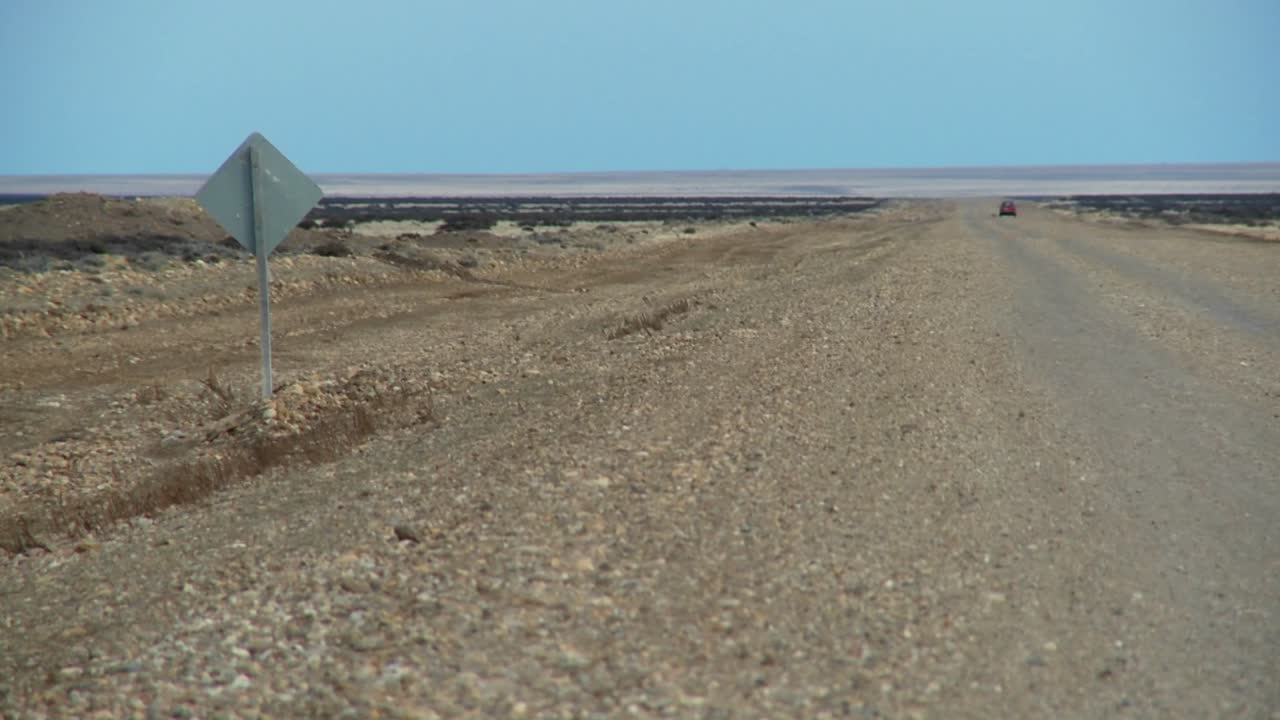 un coche distante en un camino solitario