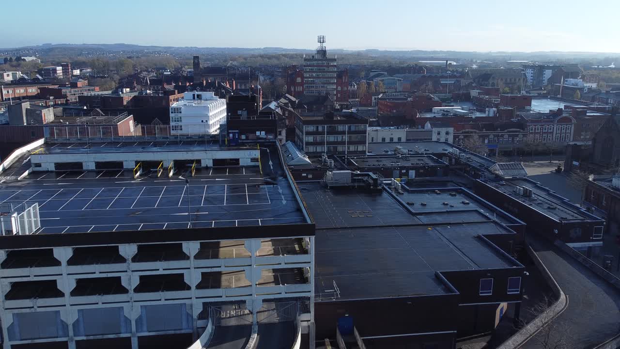 Overhead aerial view above city multi storey car park quiet British urban public streets at sunrise push in