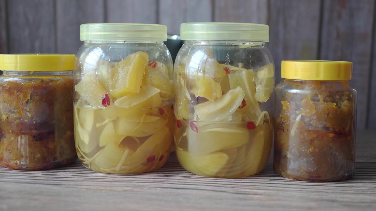 Tarros de cristal llenos de fruta en conserva sobre una mesa de madera