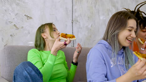 Vergrößern-Sie-Ein-Glückliches-Mädchen,-Das-Während-Einer-Party-Mit-Freunden-Zu-Hause-Spricht-Und-Ein-Stück-Pizza-Isst