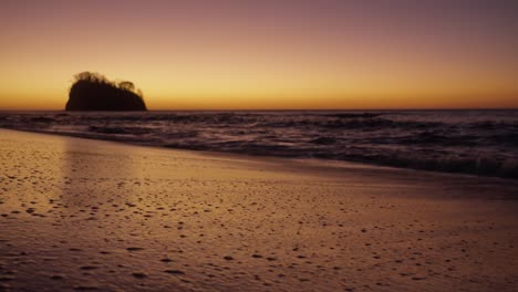 soft ocean waves reaching the shore during a warm golden sunset in costa rica. peaceful and relaxing atmosphere.