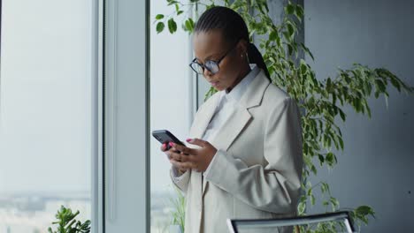 woman texting on smartphone in modern office