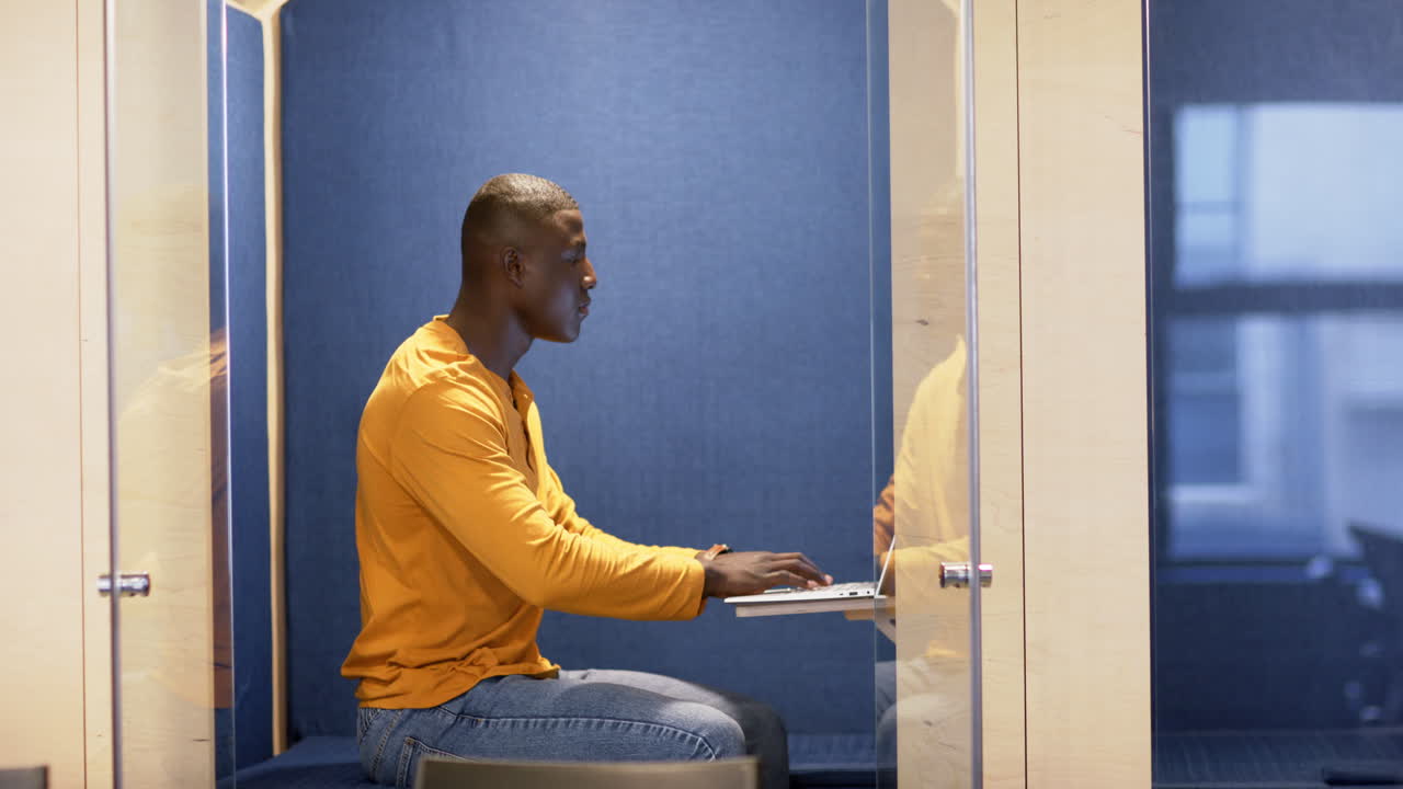 Afroamerikansk forretningsmand bruger computer på kontor, slowmotion, kopiplads.