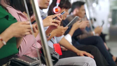 young people using mobile phone in public underground train