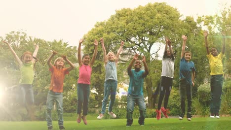Animation-of-light-spots-over-diverse-schoolchildren-jumping-in-park