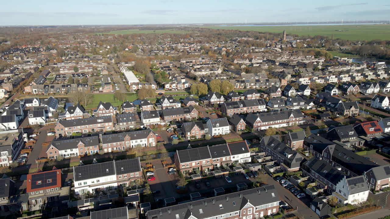 태양 전지판으로 가득 찬 지붕이 있는 현대적인 교외 지역을 향해 천천히 날아가고 있습니다.