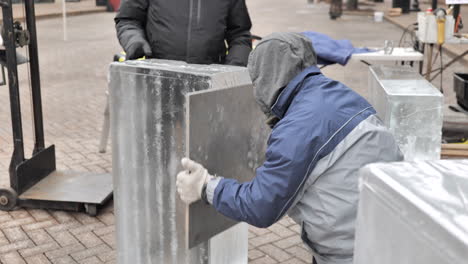 static shot of ice sculptor shaping ice block edge