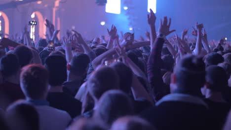 Vigorous-audience-dancing-with-hands-up-at-the-concert