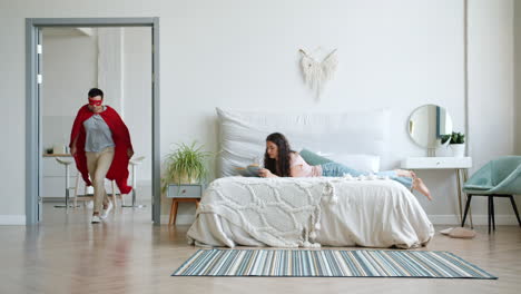 couple playing superhero in bedroom