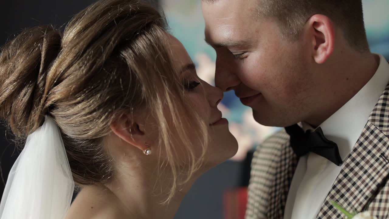 Novelli sposi. Sposo caucasico e sposa che si baciano in interni. Coppia di sposi. Uomo e donna innamorati.