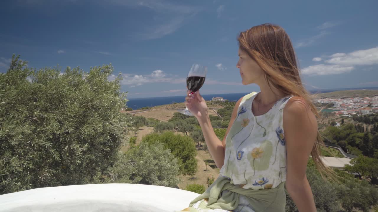 Young Woman Toasting Glass of Wine on the Balcony, Andros, Greece