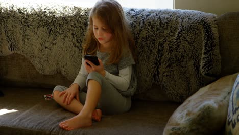 girl using mobile phone in living room 4k