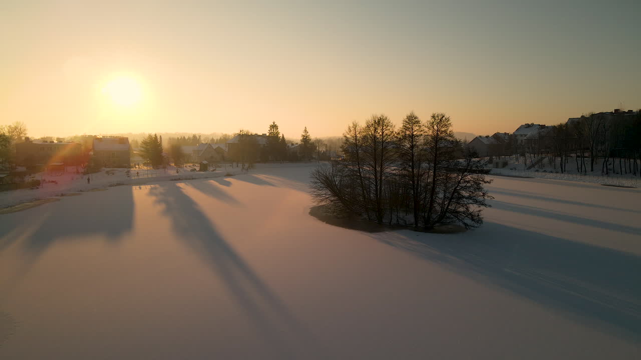 폴란드 고로보 일라베키에 있는 황금시간대에 얼어붙은 호수 한가운데 있는 작은 섬의 공중 전망
