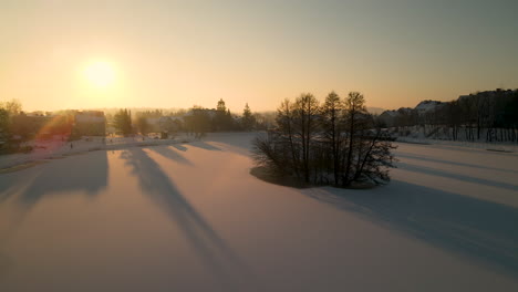 aerial view of islet in middle of frozen lake during golden hour in gorowo ilaweckie, poland