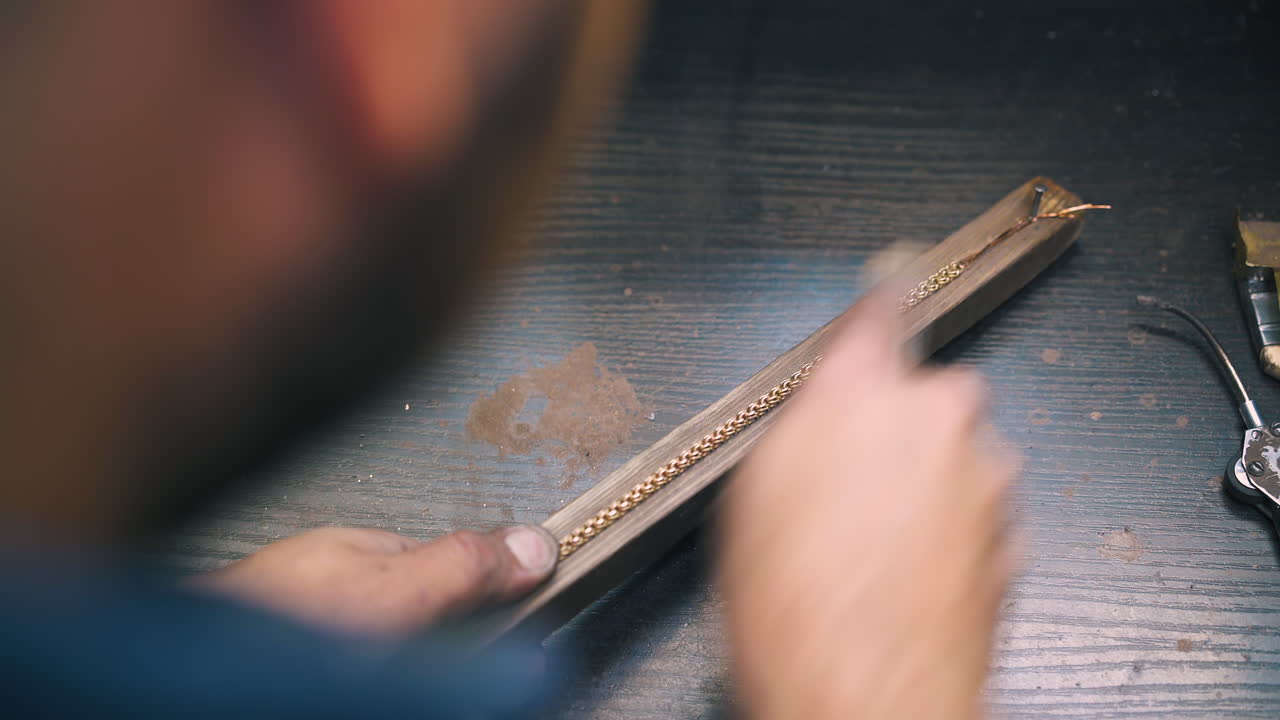 el orfebre pulió el brazalete con rasp en la parte de madera en primer plano