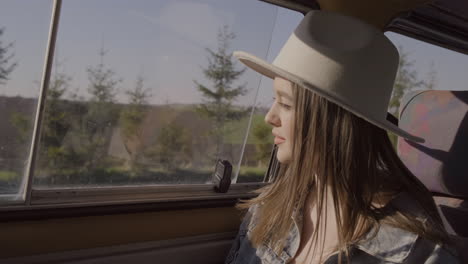 a young woman looks out the window of the caravan on a roadtrip