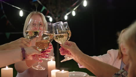 friends celebrating outdoor dinner party at night