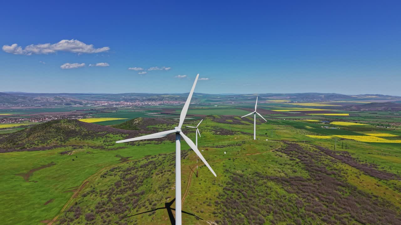 Turbine eoliche generano energia in un paesaggio verde di giorno