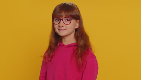 Young-toddler-school-girl-in-glasses-looking-approvingly-at-camera-showing-okey-gesture,-like-sign