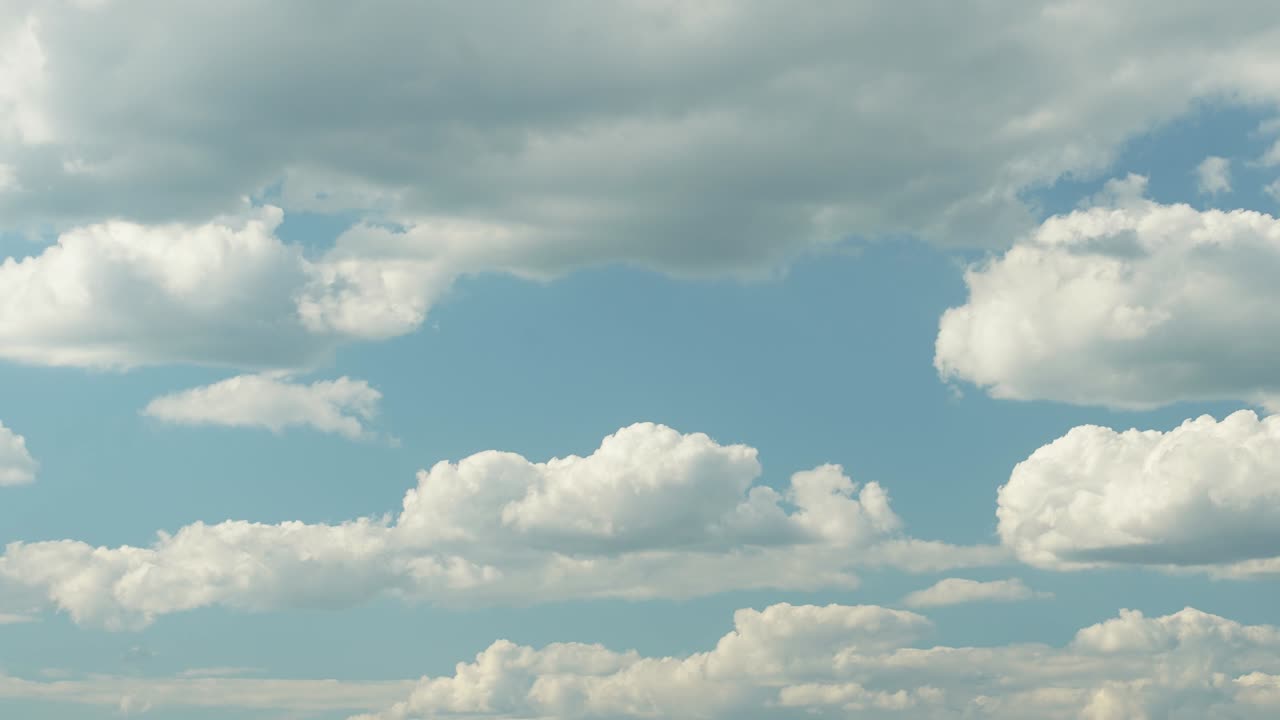 Blue summer sky with dense thick thunderstorm rain clouds moving across the heavens. Fast cloud formation and movement