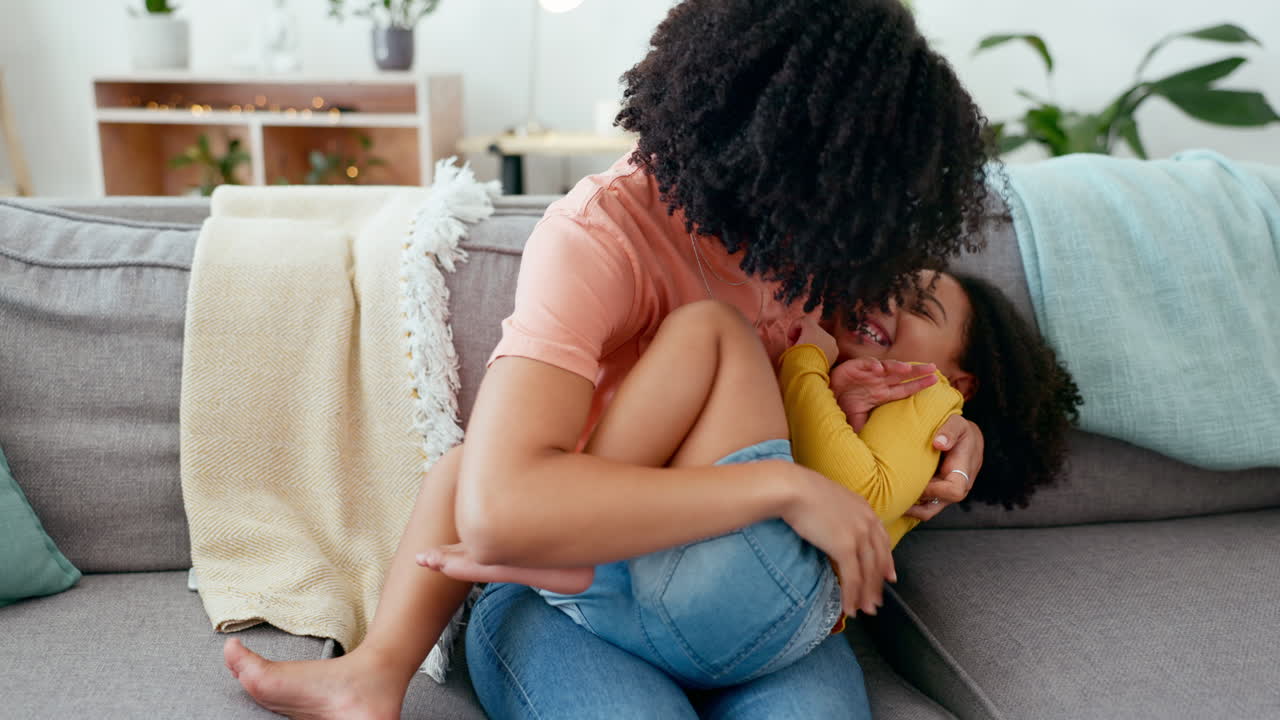 Felice, solletico e madre con figlia su un divano