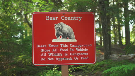 a bear country warning sign near a road inside glacier national park, montana, u