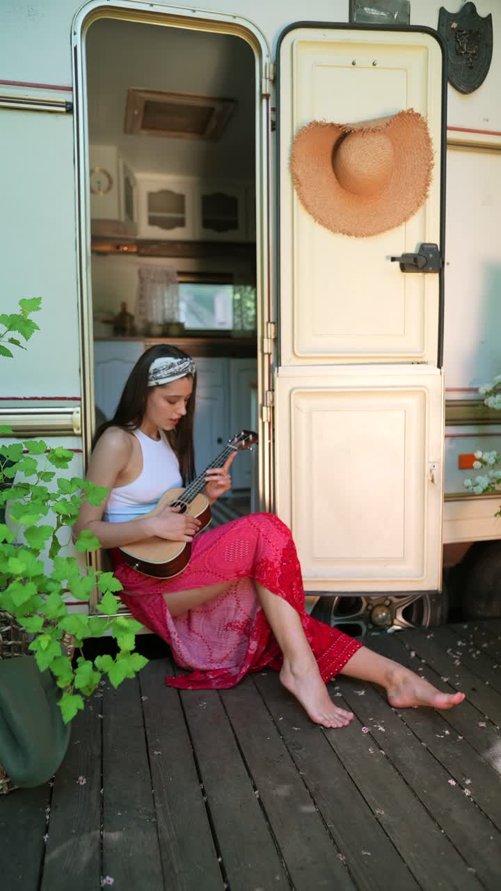 mujer tocando el ukulele en una caravana