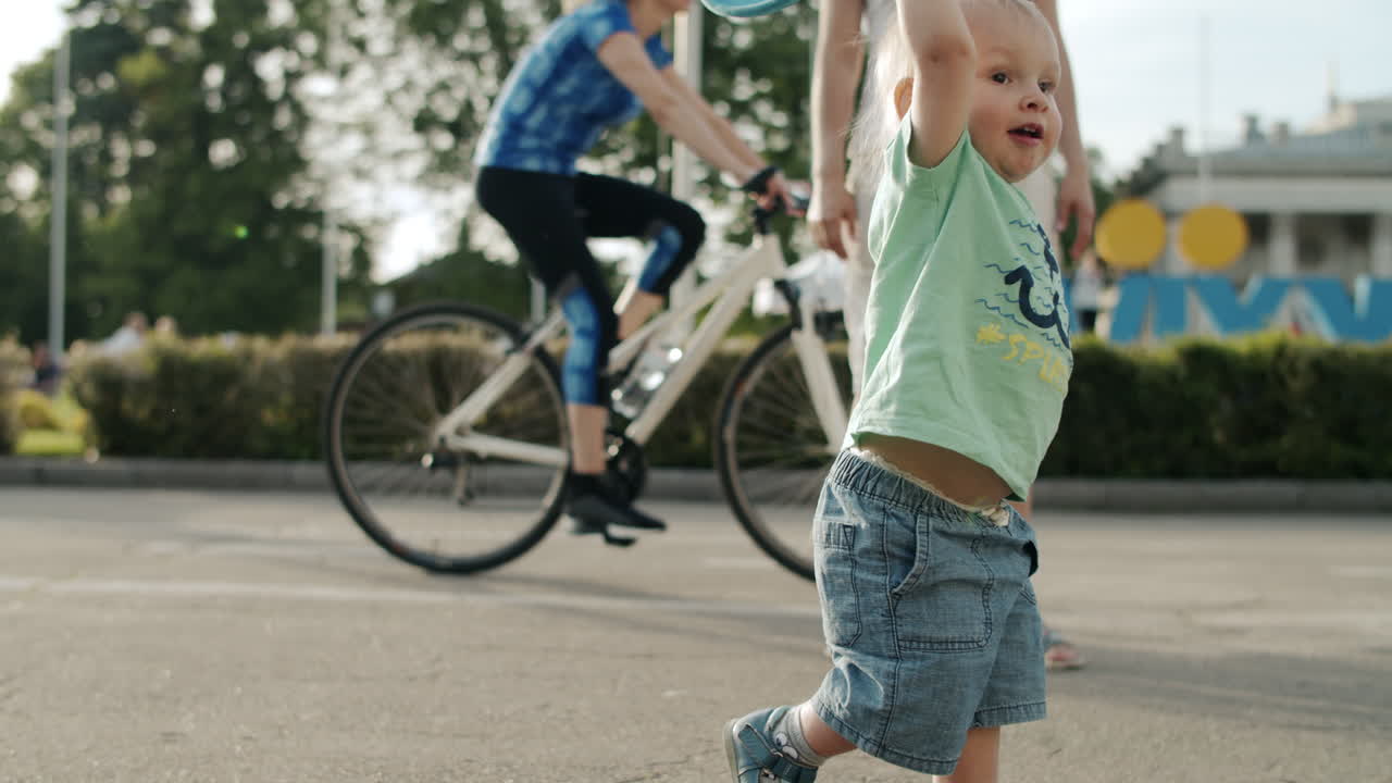 Cute boy taking frisbee plate outdoors on road