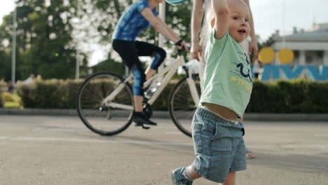 可愛い男の子が道路でフリスビープレートを外で取っている