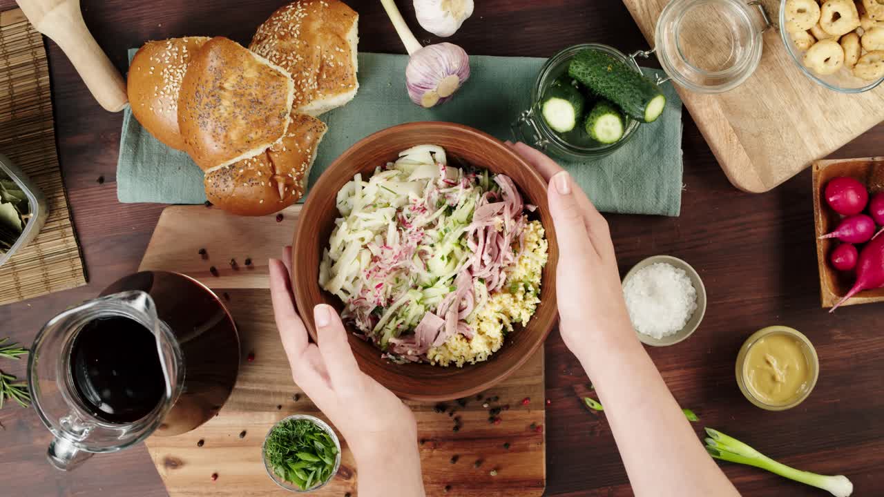 Mani che prendono una ciotola di fresca insalata Okroshka