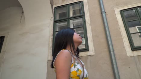 rotating shot around japanese girl in beautiful sumer dress looking up inside court of old building