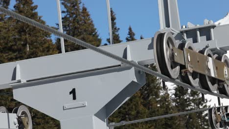 primer plano de una silla de esquí de góndola en un mecanismo de teleférico con ruedas y cuerda de acero