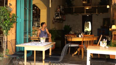 male tourist sitting alone in cafe looking around in nicosia, cyprus