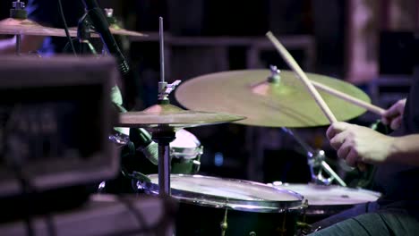 Person-playing-drums-in-concert-live