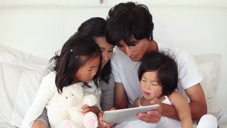 family concentrating on a tablet computer