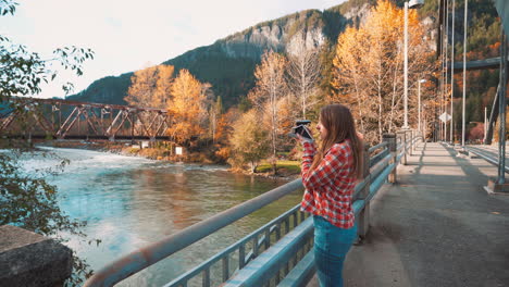 Fotógrafa-Toma-Una-Foto-Polaroid-Del-Valle-Desde-Un-Puente-Entre-Los-Colores-Del-Otoño