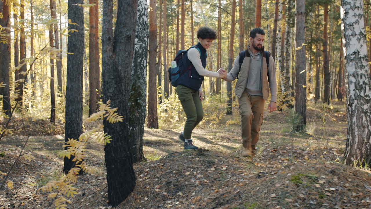 пара, гуляющая в осеннем лесу.