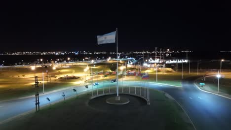 flag of argentina in the middle of roundabout in heavy wind at night