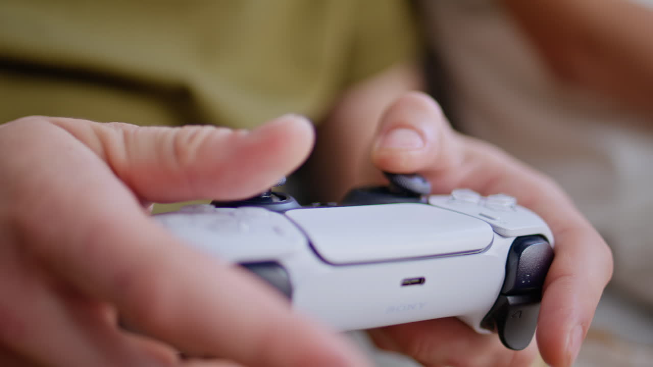 Teenager hands using gamepad at light apartment closeup. Man playing joystick