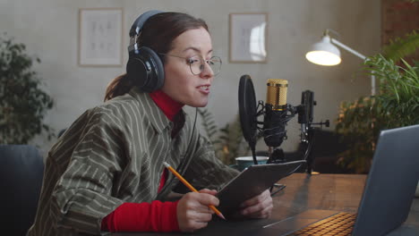 presentadora de podcast leyendo un discurso de papel en un estudio de grabación