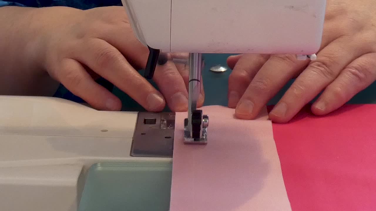 Extreme close up of a woman sewing a seam on a sewing machine
