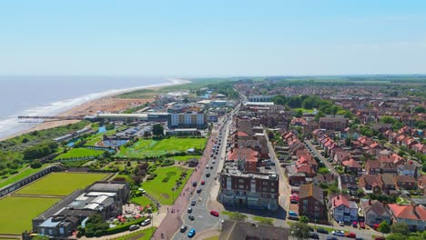 Aerial view of a bustling coastal town with a beach and pier