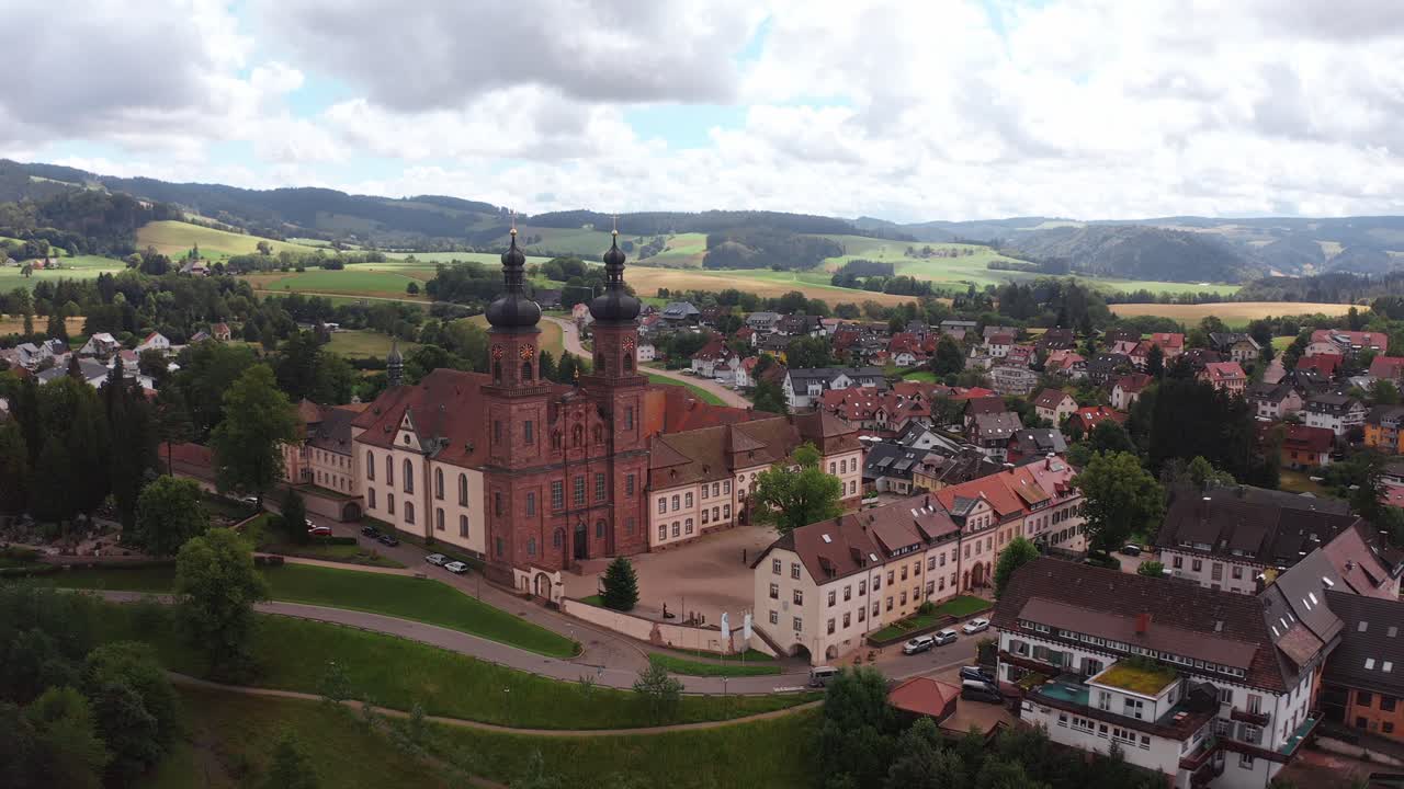 Beautiful aerial view of a village with a historical church surrounded by green hills