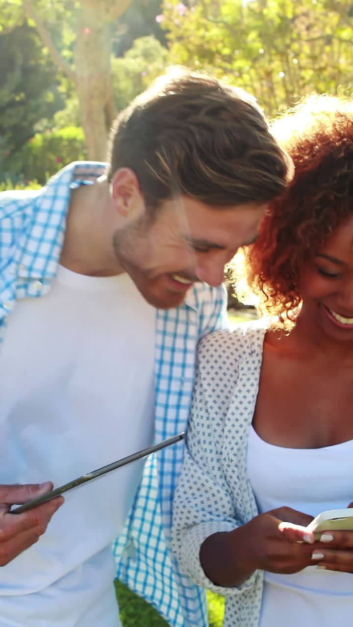 Happy couple using digital tablet and mobile phone